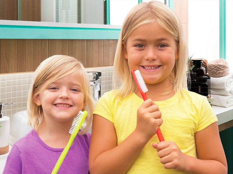 Two girls brushing their teeth