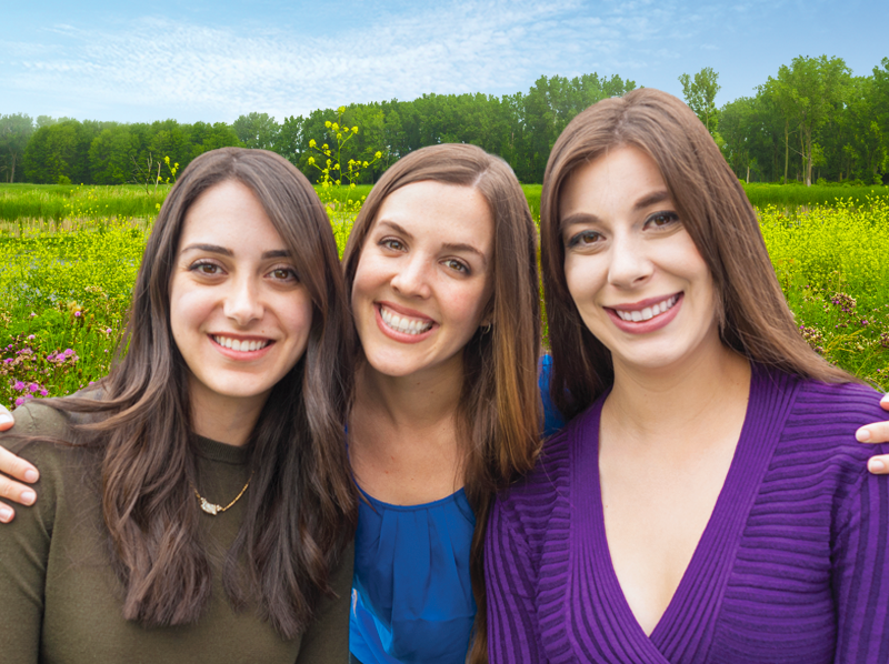 Three young women smiling at the dentist